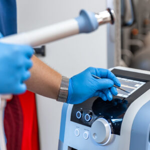 Shock wave therapy device with male doctor hands in rubber gloves, the magnetic field, rehabilitation.